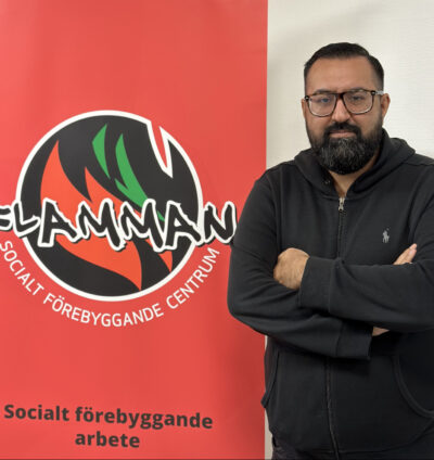 Rafi Farouq framför en affisch med Flammans logotyp