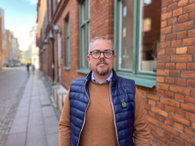 BID Malmös nye ordförande Magnus Hylthe Andersson fotograferad framför en äldre tegelfasad.